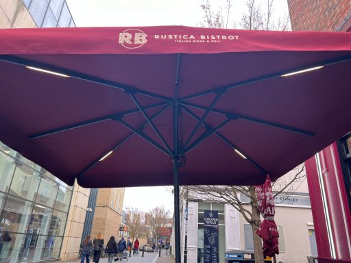 Red canopy with "RB" logo, viewed from underneath, in an urban setting.